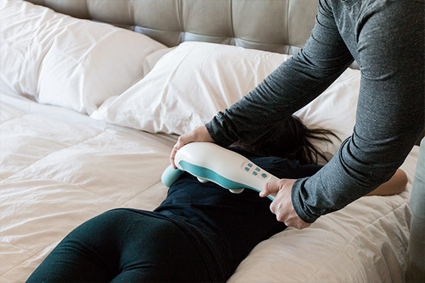 Man using the hi massager on woman's back